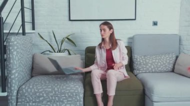 İnternette tatil yapan çok çalışan beyaz bir kadın kafa şakaklarına laptoplarını bastırıyor. Acı verici bir baş ağrısı. Uzun saatler çalışmak. Yorgunluk. İç mimari.