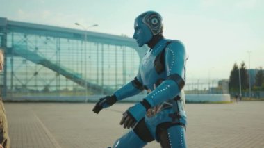 Küçük bir kız, robot arkadaşını selamlıyor ve ona sarılıyor. Gelecekteki makine zekası yapay insansı bilim robotları. Dijital sanal kurgu iletişimini yavaş çekimde kapat.