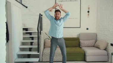 Evde dans eden mutlu genç adam hayatın tadını çıkar komik dansçı çılgın rahat daire pozitif yakın çekim ağır çekim