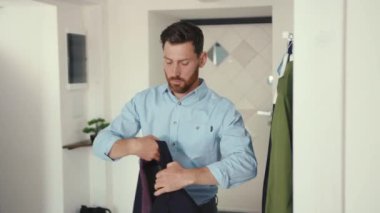 Maskeli işadamını kapat aynaya bak ve takım elbise giy. Ev güvenliği için çalış. Profesyonel apartman dairesi kordemik ağır çekim.
