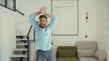 Evde dans eden sevimli genç adam hayatın tadını çıkar komik dansçı çılgın rahat daire pozitif çekim yavaş çekim