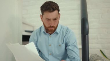 Akıllı telefon ve dokümanlarla çalışan endişeli işadamı gazeteleri tutuyor. Hüzünlü telefon, akıllı telefon, yavaş çekim.