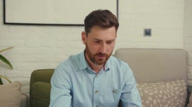 Çekici bir adam kameraya bakıp gülümsüyor. Mutlu bir işçi dizüstü bilgisayar. Evdeki internet girişimcisi, yakışıklı bilgisayar portresi.