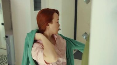 Şirin Asyalı kadın maske takıyor ve kazak giyiyor. Git ev güvenliği profesyonel koruma dairesi Corona salgınında ağır çekimde çalış.