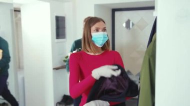 Gıda alışverişinden sonra eve dönen şık bir çift maske ceketini çıkarıp salgını önleyen karantina enfeksiyonunu karantina altına alan eşi virüsü geri getiren kişisel bakım aracı 19 yavaş çekim ile eve dönüyor.