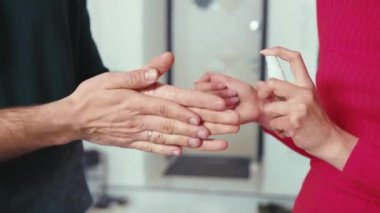 Ağır çekimde çalışan kadın ve erkek eve antiseptik sıkarak antibakteriyel virüs sıkarlar. Tıbbi temizlik enfeksiyonu. Koronavirüs alkol ilacı.