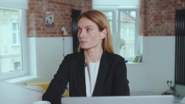 Kendine güvenen genç ve çekici iş kadını kameraya bakıyor. Ciddi başarılı girişimci portresi. Ağır çekimde kapat.