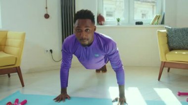 Güneş ışığında Afrika kökenli Amerikalı bir adam ev sporlarında spor kıyafetleri antrenmanı yapıyor spor kıyafetleri sportif aktiviteleri yavaş çekimde