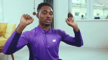 Yakışıklı antrenör Afrikalı Amerikalı adam internetten konuşuyor ve bilgisayar donanımı kullanıyor. Karantina antrenörü spor salonu spor salonu spor salonu yavaş çekim egzersizi sırasında uzaktan iletişim kuruyor.