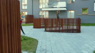 Üniformalı kurye, tıbbi maske ve eldiven takıyor. Sebzeler paketten dışarı uçuyor. Yemek dağıtımı yapıyor.