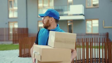 Korkmuş kurye kutuları atar ve sokak ortasında teslimatçıya koşar. Şehir içi sevkiyat emri. Karton alışveriş paketi postacısı.
