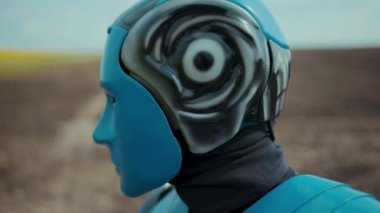 Yakın plan mavi droid cyborg aktif halde çiftlik alanındaki kameraya bakıyor. Gelecekçi robotik çiftçi. Akıllı tarım yenilikleri. Robot endüstrisi. Robocrop. Mühendislik.