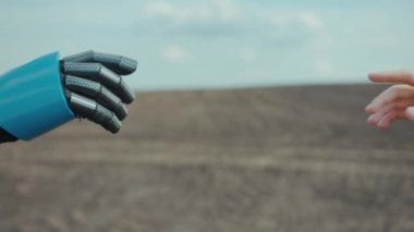 Cyborg neredeyse dokunmak üzere olan genç bir kadına el uzatıyor. Kadın ve insanımsı robot buluşması ve açık havada birbirlerini karşılamaları. Etkileşim kavramı.