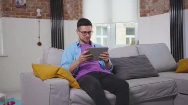 Evde arkadaşlarıyla görüntülü konuşma yapan çekici bir genç Corona virüs portresi kablosuz bağlantıyla çevrimiçi iletişim sosyal medya sohbeti yavaş çekim