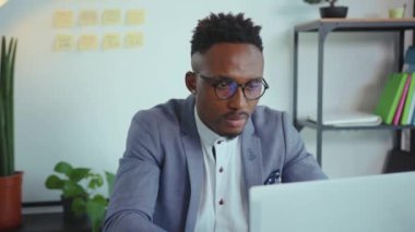 Afro-Amerikan portresi modern ofis teknolojisine gülümseyen kameraya bakın profesyonel karantina gelişigüzel iletişim yavaş çekim