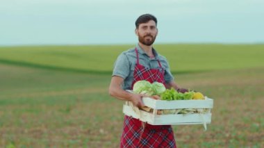 Genç çiftçi elinde organik sebzelerle yürüyor. Tarım, tarım, tarım, tarım, bahçe, beslenme, organik, taze portre.