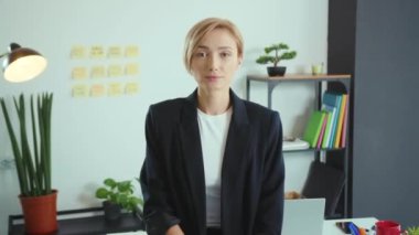 Genç bayan ofis yöneticisinin portresi kameraman kadın iş kadını pozu motivasyonlu işveren, işçiyi yavaş çekimde yakalıyor.