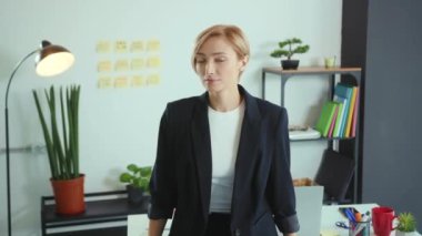 Kameraya bakıp gülümseyen genç bayan ofis müdürünün portresi. Mutlu iş kadını pozu. Motive olmuş işveren.