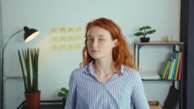 Kameraya bakan genç ve güzel bir kadın ve gülümseyen bir ofis çalışanı meşgul modern ofis çalışanı mutlu, motive olmuş, yavaş çekimde çalışan bir işveren.