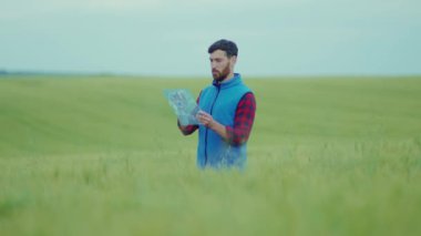 Genç adam elinde cam fütüristik aletler tutuyor yeşil alan kontrol plantasyonu deneylerinde hologram yüksek teknoloji biyolog böcek ilaçları ağır çekimde