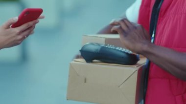 Genç Afrikalı Amerikalı kurye teslimat servisi posta kutusunu internetten alıyor. Nakliye siparişi ile ödeme yapıyor. Perakende satış paketi karantina alışverişi yapıyor.