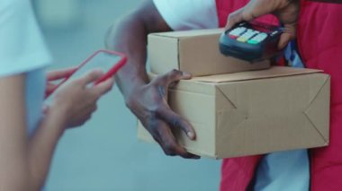 Genç Afrikalı Amerikalı kurye teslimat servisi posta kutusunu internetten alıyor. Nakliye siparişi ile ödeme yapıyor. Perakende satış paketi karantina alışverişi yapıyor.