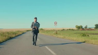 Mutlu iş adamı dizüstü bilgisayarı tek başına kullanır. Buğday tarlası özgürlük konsepti yakınında. Açık hava yakışıklı bilgisayar zarif, yavaş çekimde kazanır.