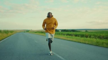 Gülümseyen Afro-Amerikan sporcusu. Güneşli yol maratonunda koşuyor. Sağlıklı spor.
