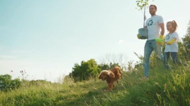 Kızları ve köpekleri olan güneş ışığı adamı ağaç bakımı yeşil grup bahçıvanı çevre tarım gezegeni ekoloji ekip çalışması yavaş çekim bahçıvanlığı