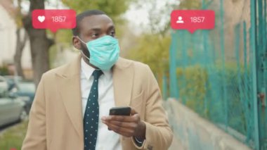 NEW YORK - 28 Mart 2020: Yüz maskesi takan Afro-Amerikalı adam, sokak koronavirüsü güvenlik salgınına karşı yorum yapan takipçi sayacı gibi sosyal medya simgeleri kullanarak sosyal medya simgeleri yazdı