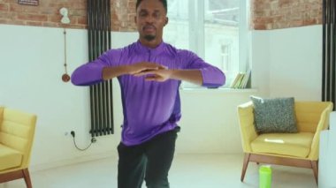 Afrikalı Amerikalı bir adam online antrenörle egzersiz yapıyor. Ev sporlarında ev bilgisayarı kullanıyor. Spor kıyafetleri, yoga sportif spor aktiviteleri yavaş çekimde.