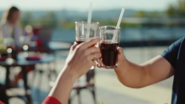 Şirin, genç, rahatlatıcı kadın ve erkek kokteyl içerek ve sokak kafesinde hamburger yiyerek yemek kız arkadaş yemeği, neşeli, yavaş çekimde portre.