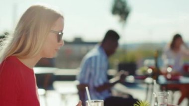 Genç, rahatlatıcı, kokteyl içen, patates kızartması yiyen, sokak kafesinde sohbet eden genç bir adamla, yemek yiyen, neşeli, yavaş çekim portresi olan bir kız arkadaş.