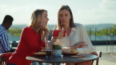 İki kadının dinlenme sohbetini kapat. Yaz Kafe Sokağı Kardeşler Kafesi 'nde telefon kokteyli iç. Şehir arkadaşlığı modelleri dışarıda yavaş çekim.
