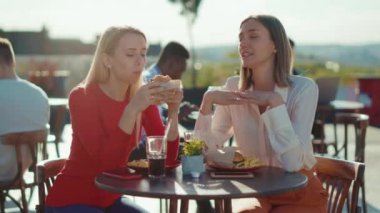 İki kadının dinlenmesini, telefon konuşmasını, kokteyl içmesini, yaz cafe caddesindeki kız kardeşlerin kafede burger yemelerini, günlük arkadaşlık modellerini, ağır çekimde dışarıda konuşmalarını kapatın.