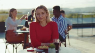 Çekici genç bir kadın, kameraya bakar açık kafede gün ışığında gülümser. Günlük yaşam tarzı, kendine güveni tam. Yavaş çekimde kendine güveni tam.