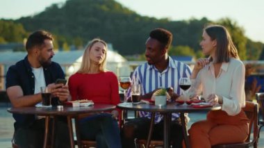 Hüzünlü şirket arkadaşlarını kapatıyoruz. Sokak kafesinde oturuyorlar. Akıllı telefonlar kullanıyorlar.