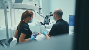 Tıbbi klinik stomatoloji uzmanı, diş hijyeni uzmanı, asistanı ve müvekkili ile dişçiyi kapatın.