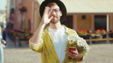 NEW YORK - 19 Nisan 2020: Çiçekli genç adam erkek arkadaşını bekliyor dışarıda el sallıyor gay arkadaşlık ilişkisi yaşam tarzı homoseksüel lgbt ağır çekim