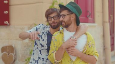 Portre genç iki eşcinsel erkek etrafa bakınıyor mutlu homoseksüel bir çiftin LGBT ilişkisi yaşadığını gösteriyor açık havada gülümseyen sevgili çekici yavaş çekim.