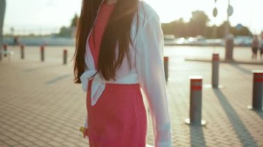 Çin kökenli genç bir kız valiziyle havaalanı terminaline doğru yürüyor. Gülümsüyor, mutlu bir yaz tatili geçiriyor. Gün doğumunda dışarıda yürüyor..