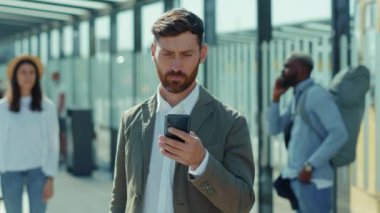 Portre yakışıklı adam akıllı telefon animasyon 3d yüz tanıma maskesini kullanın otobüs durağında gülümseyen kameraya bakın neşeli bir şekilde yazarak yetişkin gün ışığını yavaş çekimde kaydır