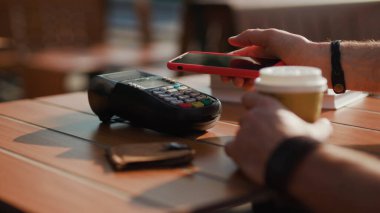 Eller NFC teknolojisiyle ödeme yapıyor. Kafede akıllı telefon kartı başvurusu. Dijital elektronik kablosuz finansal mobil terminal aktarımı.
