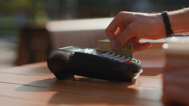 Güneş ışığında, müşterinin kredi kartıyla ödemesi kafeteryada tutulur telefon finansmanı finansman finans finansmanı finans terminali iletişim makinası elektronik alışveriş kasası yavaş çekim kasası