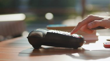 Güneş ışığında, müşterinin kredi kartıyla ödemesi kafeteryada tutulur telefon finansmanı finansman finans finansmanı finans terminali iletişim makinası elektronik alışveriş kasası yavaş çekim kasası