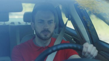 Ciddi bir genç adam araba kullanıyor. Gün batımı yolculuğunda. Mutlu bir macera arabası. Kısa saçlı, serbest zaman yolculuğu.