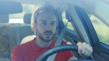 Gülümseyen genç bir adam araba kullanıyor gün batımında günbatımında yolculuk mutlu bir macera arabası kısa saçlı serbest zaman yolculuğu gülümsüyor yavaş çekimde yaz yolculuğu