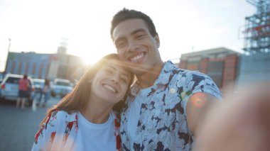 NEW YORK - 10 Haziran 2018: Yakın plan mutlu kız ve erkek arkadaşı komik selfie çekiyorlar kameraya bakarak birbirlerine sırıtarak gülüyorlar. Arka planda modern şehir manzarası.