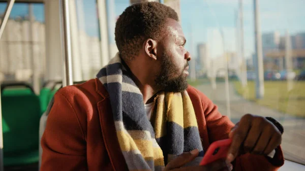 Face smiling young african american man use smartphone sitting in tram traffic typing at sunny day handsome passangers stylish transportation using way internet online texting portrait guy slow motion