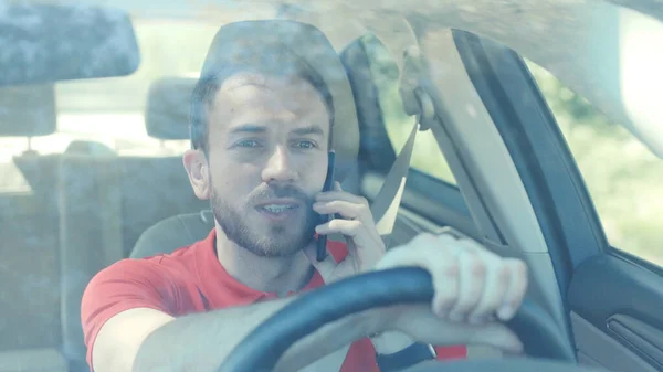 Portrait smiling young handsome happy man use phone in the car look at camera driver mobile automobile cell drive hand smartphone auto business communication traffic businessman telephone